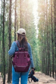 Young female woman lifestyle photographer travel taking photo in forest nature with backpack and copy space.