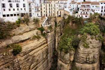 Traditional houses on a high cliffs of El Tajo Gorge in Ronda town, Andalusia, Spain.