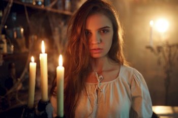 Crazy demonic woman with candle choosing potions, demons casting out. Exorcism, mystery paranormal ritual, dark religion, night horror. Crazy demonic woman with candle choosing potions
