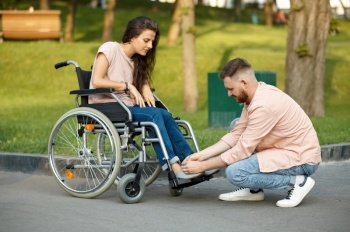 Love couple, care for a disabled woman in wheelchair. Paralyzed people and disability. Husband and wife overcome difficulties together, warm relationships. Love couple, care for disabled woman in wheelchair