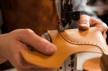 Close up of a cobbler stitching a part of the shoe at a workshop. Close up of a cobbler stitching a part of shoe