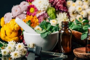 Bach Flower Remedies - Alternative Herbal Medicine. Dropper bottles, flowers, and mortar and pestle full of fresh mint . Bach Flower Remedies – Alternative Herbal Medicine