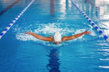 Female swimmer on training in the swimming pool. Butterfly  swimming style