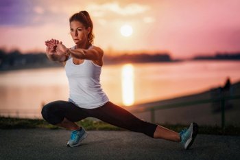 Woman Exercising Outdoors by the Water . Woman Stretching by the Water 