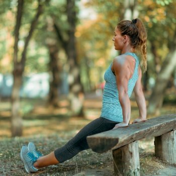 Woman Exercising Outdoors In Autumn in Public Park
