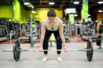 Athletic woman exercising deadlift in a gym. High quality photo. Athletic woman exercising deadlift in a gym.