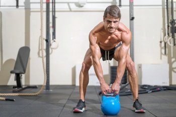Young Fit man training with kettlebells. High quality photo. Young Fit man training with kettlebells.