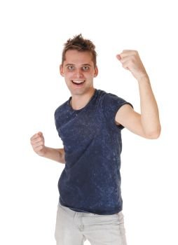 A young very happy man standing in a blue sweater and gray jeans, smiling, with his fists up into the air, isolated for white background