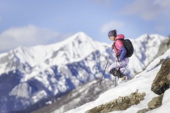 Woman mountaineer downhill with crampons on snowy slope