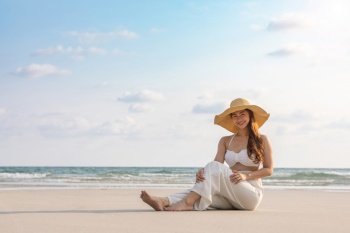 Attractive Asian young woman wearing white dress smile enjoy with summer vacation on the beach feeling so happiness and cheerful,Travel in tropical beach in Thailand,vacations and relaxation Concept
