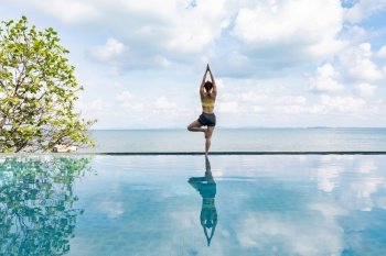 woman practice yoga lotus pose to meditation summer vacation on the pool above the beach,Travel in tropical beach Thailand,vacations and relaxation Concept