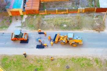 Workers, excavator, roller compactor repair road, top view, Kiev, Ukraine