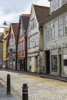 BERGEN, NORWAY - 05 MAY 2013: Street of Bergen with old wooden houses and tiled roofs.