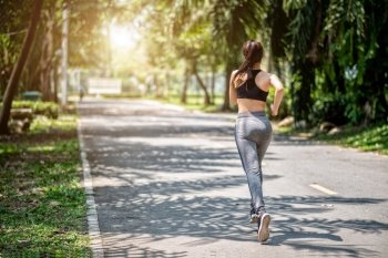 Pretty sport woman jogging in the park, running outdoors in nature
