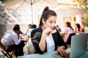 Busy young business woman working on desk using laptop in coffee shop