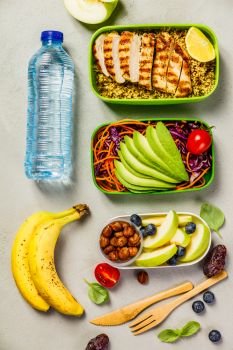 Healthy meal prep containers: Couscous with grilled chicken breast, salad, avocado, berry, apple, nuts and dry dates. Keto, ketogenic diet, low carb, healthy food concept. Top view. Healthy lunch in boxes
