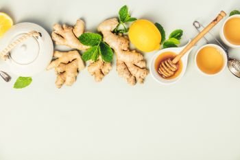 Ginger tea with lemon, honey and mint on grey concrete background. Top view, flat lay