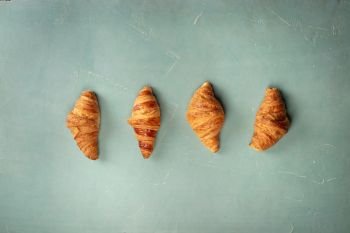 Fresh croissants on rustic concrete background, flat lay. Fresh Croissants on blue background, flat lay