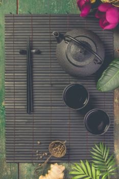 Asian food background - tea and chopsticks on dark rustic background. Top view, flat lay. Asian food background - tea and chopsticks on dark rustic background.
