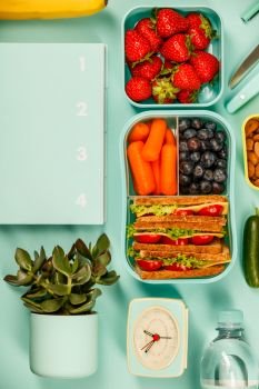 Creative flat lay with healthy lunch and office or school supplies on pastel colors background. Creative flat lay with healthy lunch and office or school supp