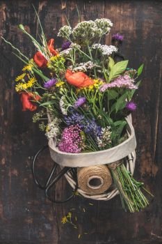 Bouquet of wild flowers in a basket. Flat lay, top view