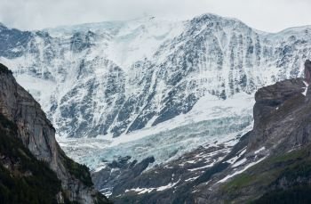 Summer Alps mountain landscape with glacier and snow covered rocky tops in far, Switzerland.