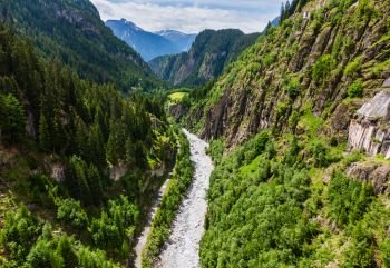 Summer Alps mountain landscape with deep ravine canyon and rapid river stream in Switzerland.