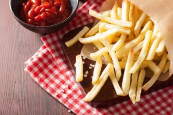 french fries with ketchup over rustic background