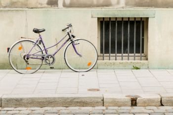 An old bicycle leaning on wall in city building