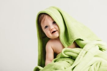 Little toddler covered in cozy blanket. Funny sweet baby. Childhood.. Little toddler covered in cozy blanket.