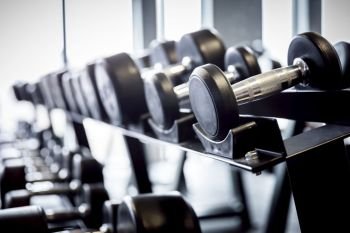 Rows of dumbbells on a rack in the gym. Weightlifting, training equipment.. Rows of dumbbells on a rack in the gym.