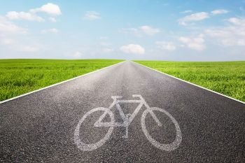 Bike symbol on long straight asphalt road, way. Conceptual - travel, ecological transportation etc.