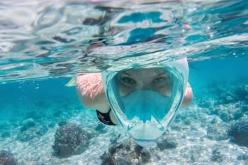 Woman snorkeling underwater in Indian Ocean, Maldives. Clear turquoise water.. Woman snorkeling underwater in Indian Ocean, Maldives