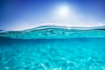 Half underwater shot, clear turquoise water and sunny blue sky. Tropical ocean. Half underwater shot, clear water and sunny blue sky. Tropical ocean