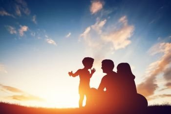 Happy family together, parents with their little child sitting on grass at sunset. Happy family together, parents with their little child at sunset.
