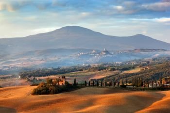 Tuscany landscape at sunrise. Typical for the region tuscan farm house, hills, cypress trees. Italy. Tuscany landscape at sunrise. Tuscan farm house, cypress trees, hills.