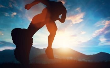 Man running towards the sunset in the mountains. Outdoor activities. Exercising and workout.. Man running towards the sunset in the mountains
