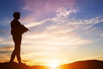 Armed soldier with rifle standing and looking on horizon. Silhouette at sunset. War, army, military, guard.. Armed soldier with rifle. Guard, army, military, war.