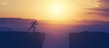 Man running towars cliff in the mountains on a sunset sky. Energy, victory and taking risks.. Man running towars cliff in the mountains.