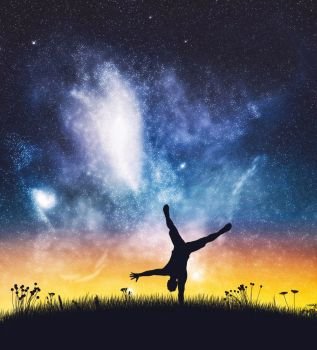 Acrobat man standing on one hand on starry night sky. Silhouette on the field. Energy, happiness.. Acrobat man standing on one hand on night sky.