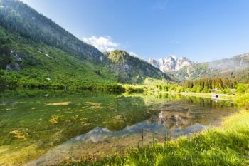 Austrian landscape with forests, meadows, fields and pastures surrounding the lake Gosausee on the background of Alps