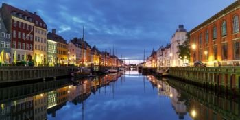 Panorama of Nyhavn with colorful facades of old houses and old ships in the Old Town of Copenhagen, capital of Denmark.. Panorama of Nyhavn in Copenhagen, Denmark.