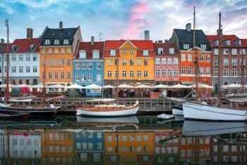 Nyhavn at sunrise, with colorful facades of old houses and old ships in the Old Town of Copenhagen, capital of Denmark.. Nyhavn at sunrise in Copenhagen, Denmark.