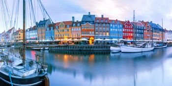 Panorama of north side of Nyhavn with colorful facades of old houses and old ships in the Old Town of Copenhagen, capital of Denmark.. Panorama of Nyhavn in Copenhagen, Denmark.