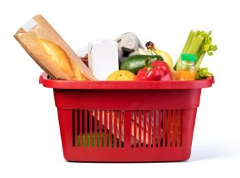 Plastic shopping basket with of grocery products isolated on white. Plastic shopping basket
