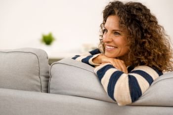 Beautiful woman sitting on the sofa  and smiling
