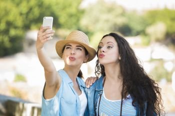 Two beautiful female friends making a selfie with cellphone