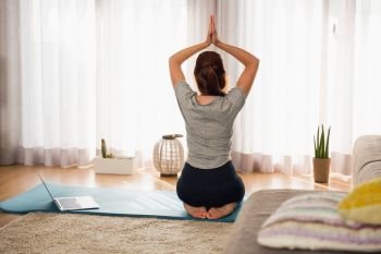 Full length shot of a woman doing yoga
 at home