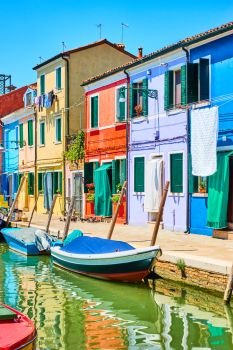 Colorful small houses by canal in Burano, Venice, Italy                                                             