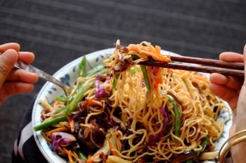 Fry noodles mixed vegetables, a Vietnamese vegetarian dish for vegans, with colorful greens, vermicelli and mushrooms, quick to  make for breakfast at home